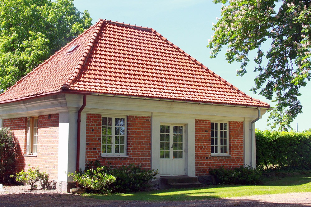 Litet bostadshus i vit puts och tegel