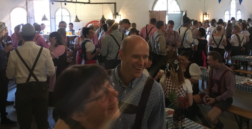 Bild från oktoberfesten, uppklädda människor i samlingsrum.